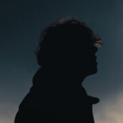 Silhouette von Skofi schulteraufwärts vor einem dunkelblauen Himmel