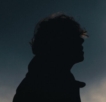 Silhouette von Skofi schulteraufwärts vor einem dunkelblauen Himmel